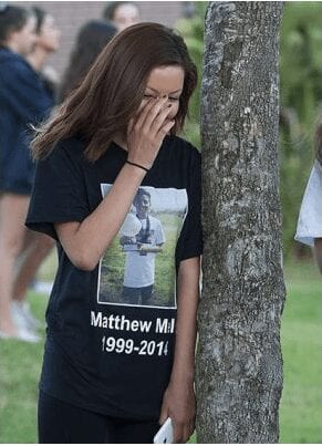 Ashley Bello, 14, of San Juan Capistrano wears her friend Matthew Melo's image. He died in a car crash Sat. morning. A vigil was held at Capistrano Valley High in Mission Viejo. (Photo from Orange County Register)